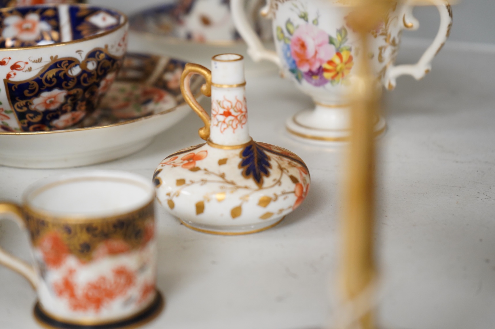 A collection of late 18th/19th century English and French porcelain coffee cans, tea cups and vases, some in Imari pattern